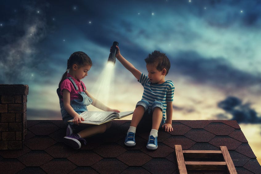 Children reading a story on a roof