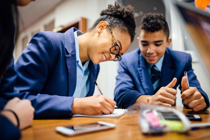 students writing in their school exercise books