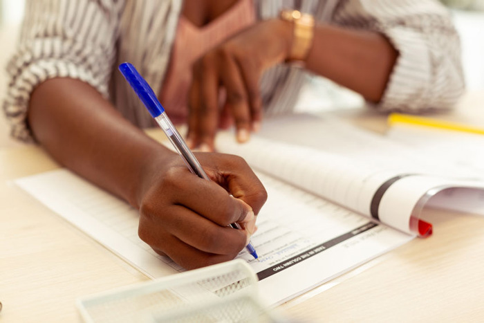 Students writing in their exercise books for schools