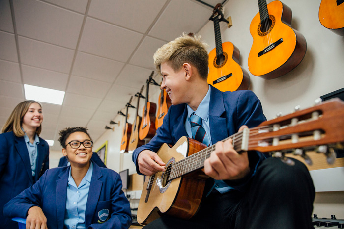 student playing guitar at school