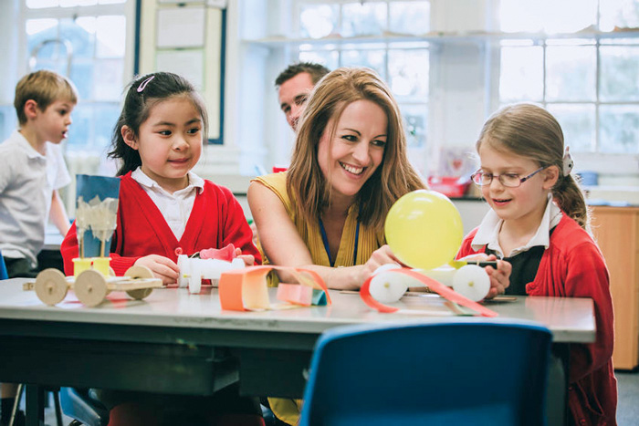 teacher supporting pupils in classroom