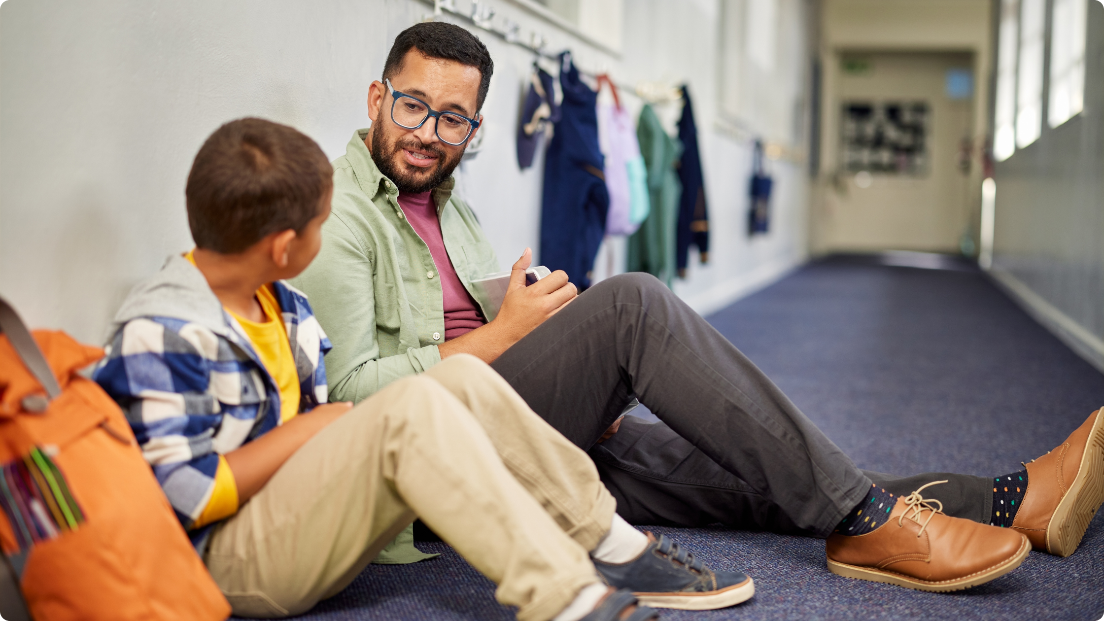 Example of SEND provision: teacher offering one-to-one support to a pupil in a mainstream school hallway.